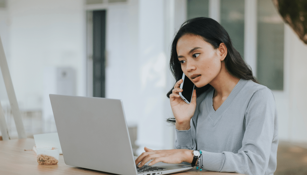 femme au telephone devant un ordinateur portable