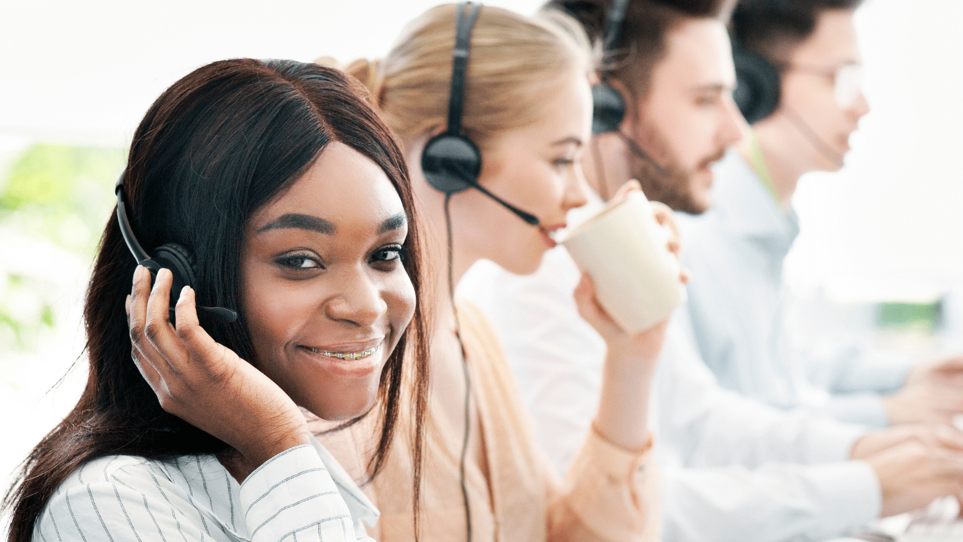 Quatre personnes, deux femmes et deux hommes, casquées en train de faire de la permanence téléphonique