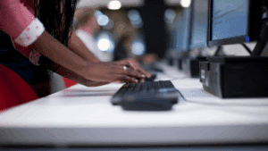 Mains d'une jeune femme faisant de la saisie de données à distance sur un ordinateur